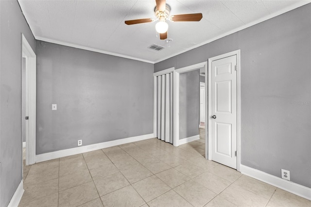 unfurnished bedroom with ceiling fan, light tile patterned flooring, and crown molding