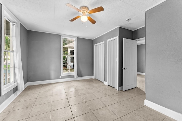 unfurnished bedroom featuring ceiling fan and light tile patterned floors