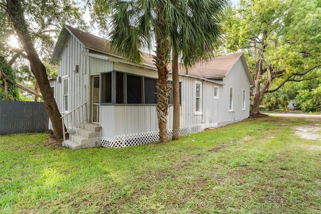 rear view of property featuring a lawn