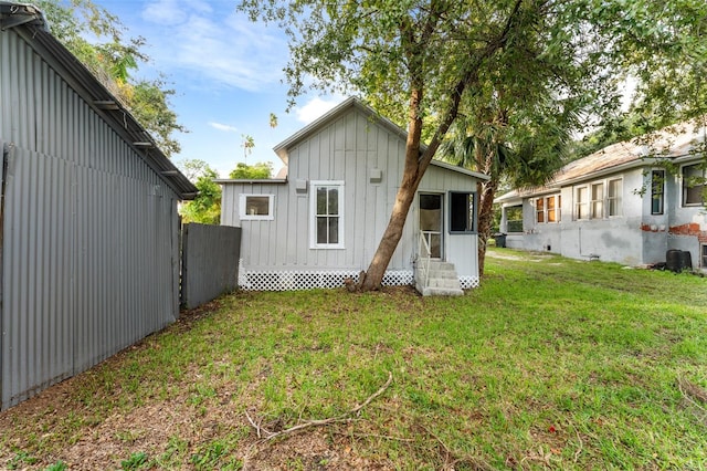 back of property with a yard and central air condition unit