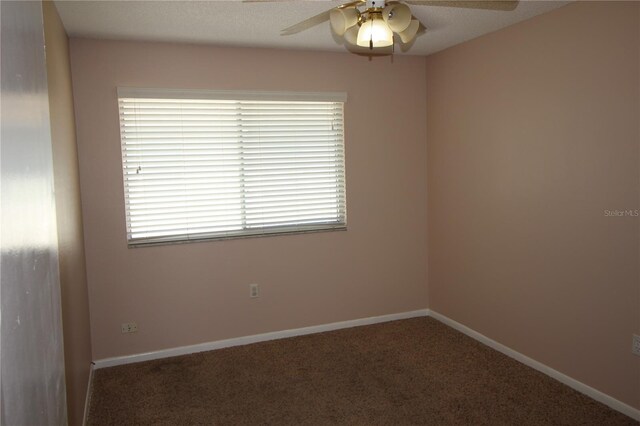 carpeted empty room featuring ceiling fan, plenty of natural light, and a textured ceiling