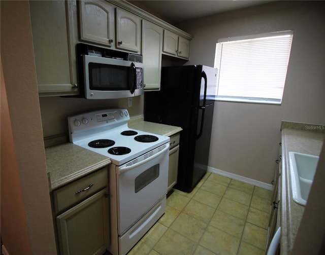 kitchen featuring sink, light tile patterned floors, and white electric range