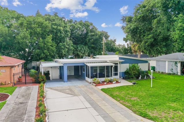 ranch-style home with a front yard, a carport, and a sunroom