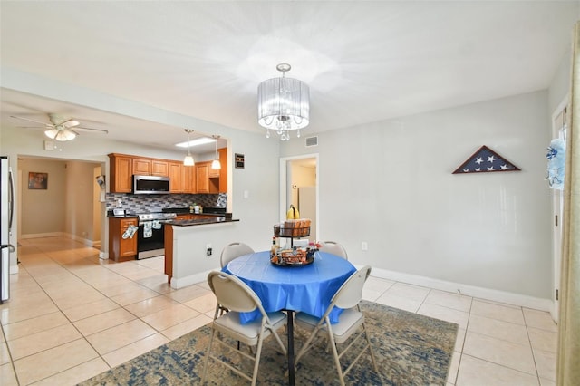 dining room with ceiling fan with notable chandelier and light tile patterned floors