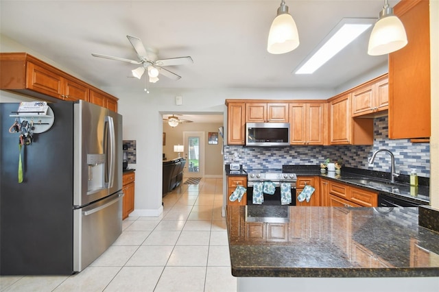 kitchen featuring stainless steel appliances, sink, pendant lighting, and backsplash