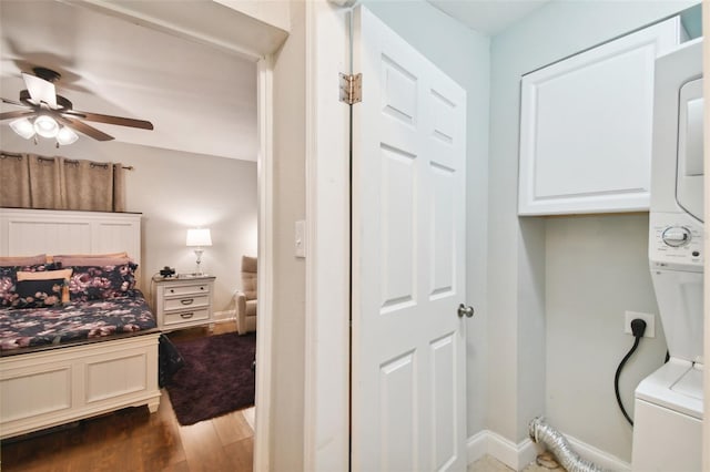 bedroom with hardwood / wood-style flooring and stacked washer and clothes dryer