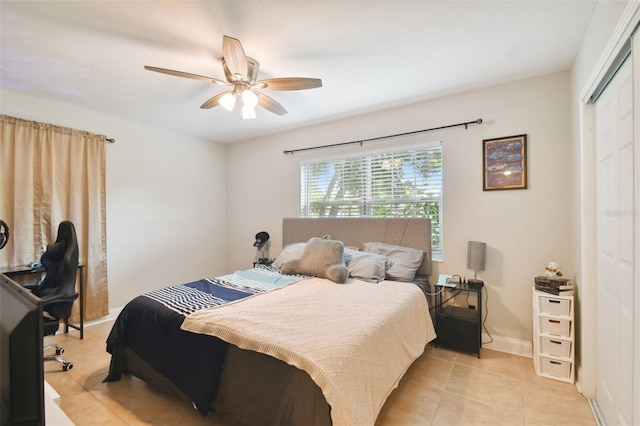 bedroom with light tile patterned floors, ceiling fan, and a closet