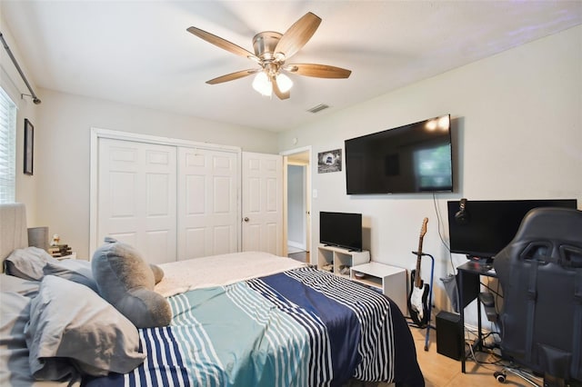 tiled bedroom featuring ceiling fan and a closet