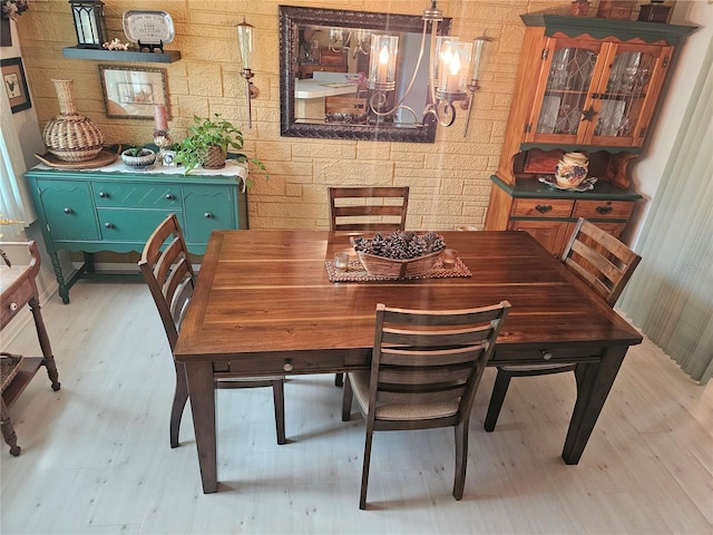 dining area with light wood finished floors and a notable chandelier