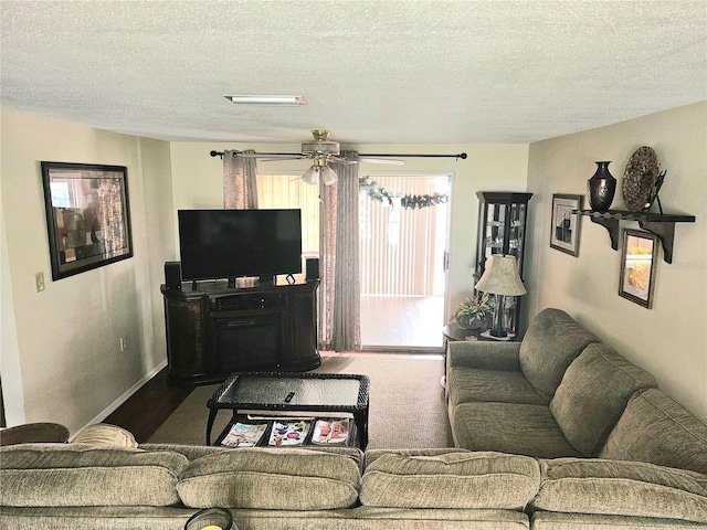 living room featuring a textured ceiling, ceiling fan, and carpet