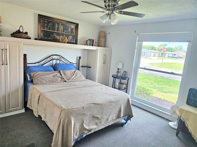 carpeted bedroom featuring a textured ceiling and a ceiling fan