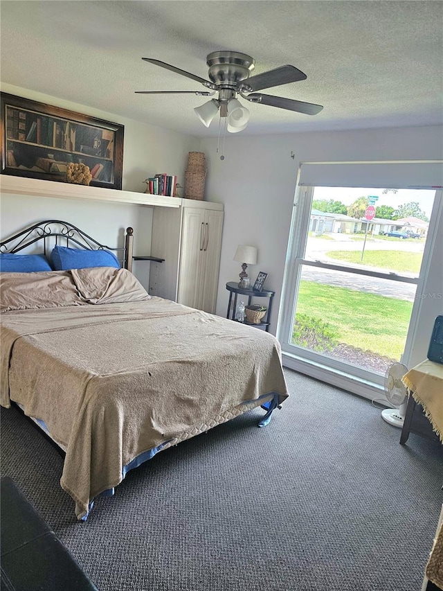 bedroom with carpet, ceiling fan, and a textured ceiling