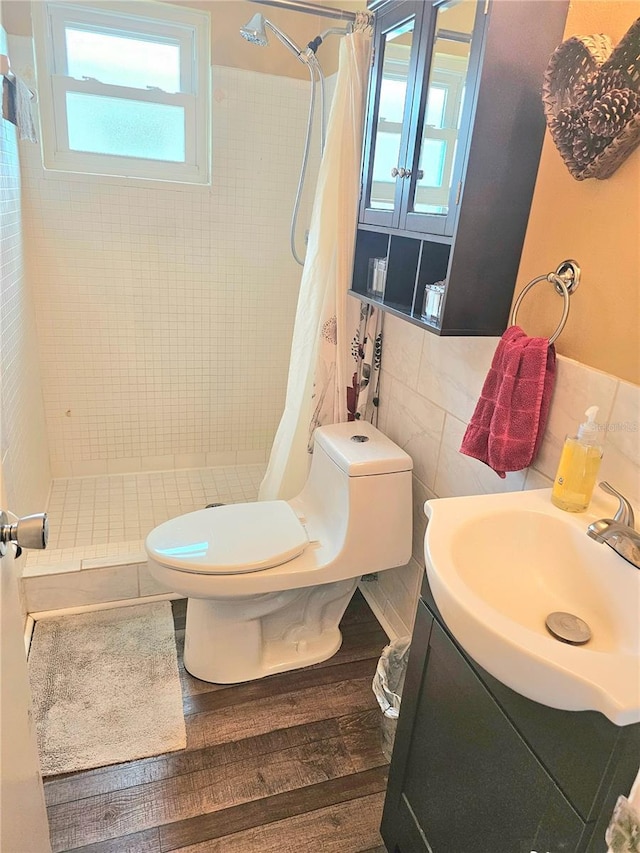 full bath with toilet, vanity, a shower stall, and tile walls