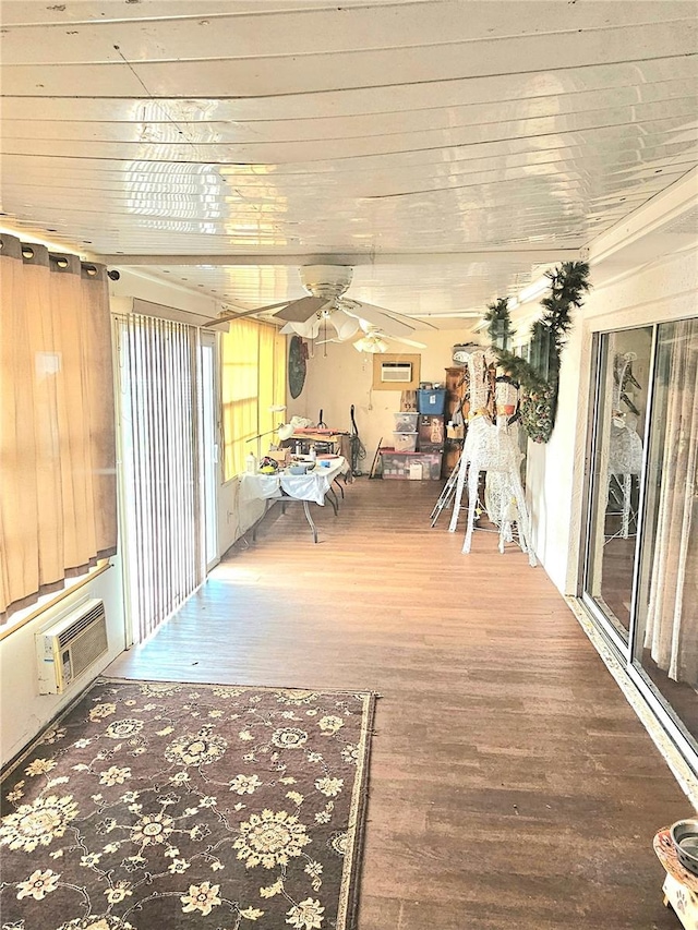 sunroom / solarium with ceiling fan, a wall unit AC, and wood ceiling