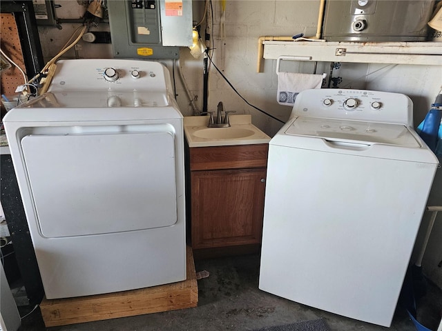 washroom with laundry area, washing machine and dryer, electric panel, and a sink