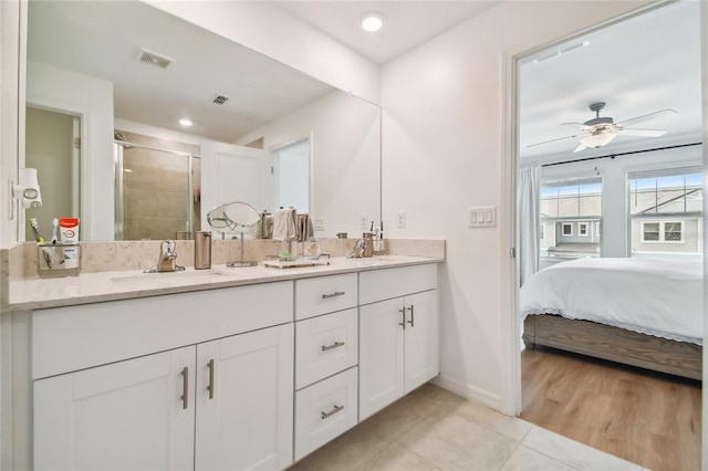 bathroom featuring ceiling fan, vanity, tile patterned flooring, and a shower with door