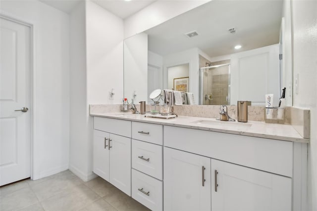 bathroom featuring tile patterned floors, vanity, and a shower with door