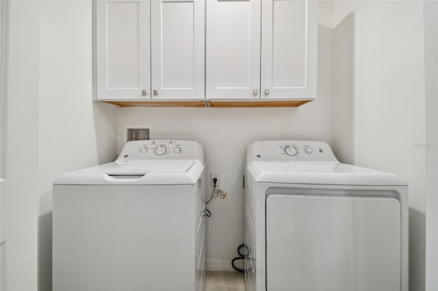 laundry room with washing machine and dryer and cabinets