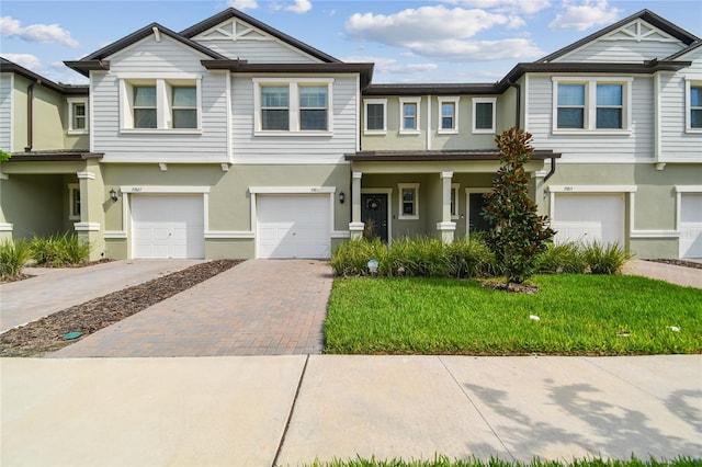 view of property with a garage and a front lawn