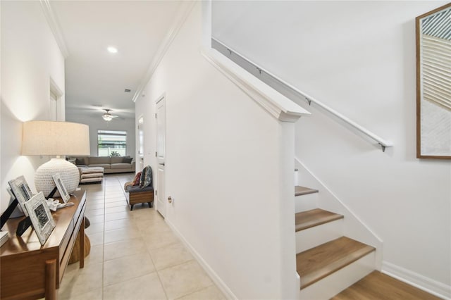 stairway with crown molding, tile patterned flooring, and ceiling fan