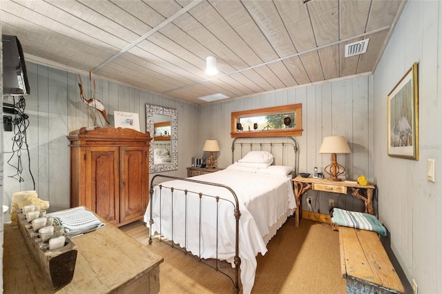 bedroom featuring light carpet and wood walls