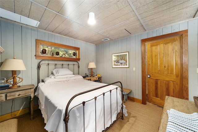 carpeted bedroom featuring wooden walls