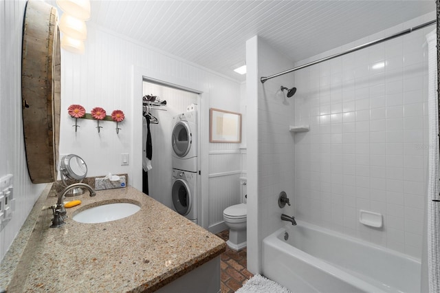 full bathroom featuring toilet, crown molding, bathtub / shower combination, stacked washing maching and dryer, and vanity