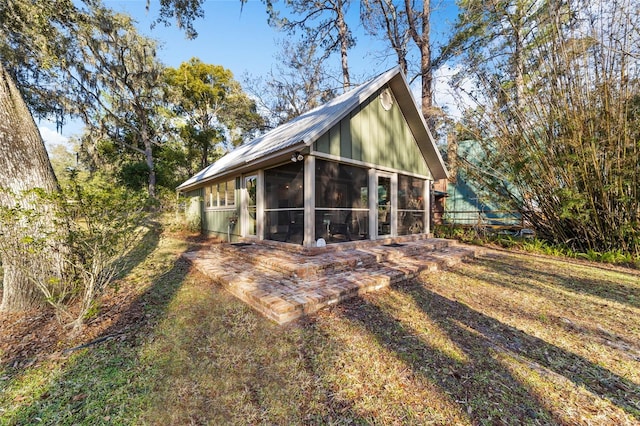 rear view of property featuring a sunroom