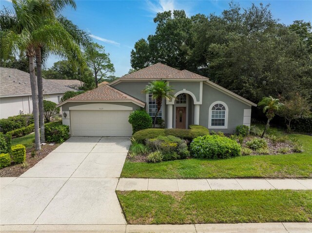 mediterranean / spanish-style house with a front lawn and a garage