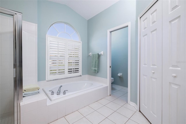 bathroom with tile patterned flooring, a wealth of natural light, lofted ceiling, and toilet