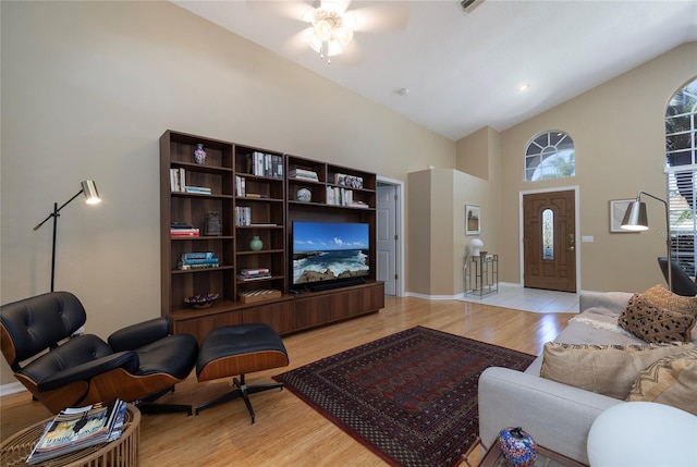 living room featuring high vaulted ceiling, light hardwood / wood-style floors, and ceiling fan