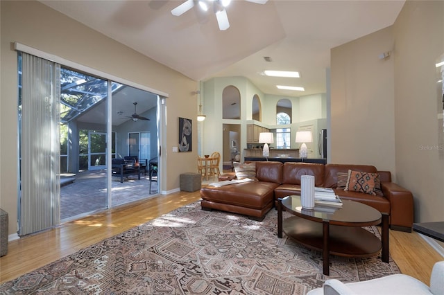 living room featuring hardwood / wood-style floors, high vaulted ceiling, and ceiling fan