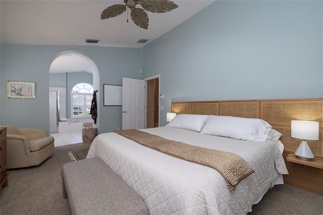 bedroom featuring ceiling fan, ensuite bath, lofted ceiling, and light tile patterned floors