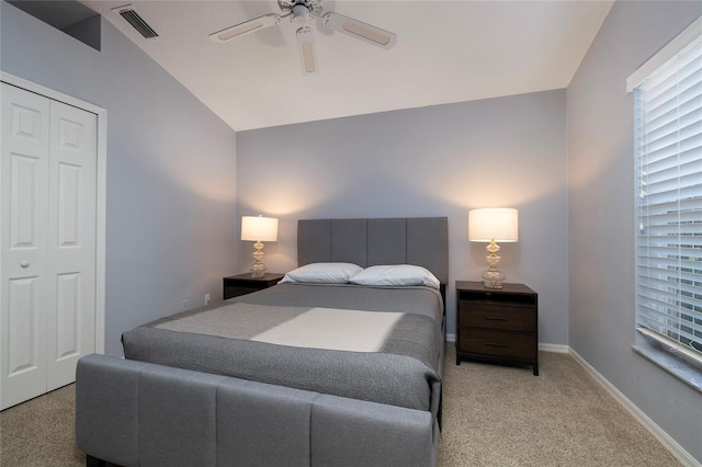 bedroom with lofted ceiling, light colored carpet, ceiling fan, and a closet