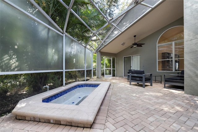 view of pool featuring an in ground hot tub, ceiling fan, glass enclosure, and a patio area