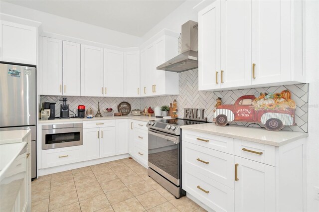 kitchen featuring white cabinetry, wall chimney exhaust hood, stainless steel appliances, backsplash, and light tile patterned flooring