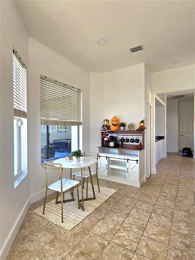 tiled dining space featuring a textured ceiling