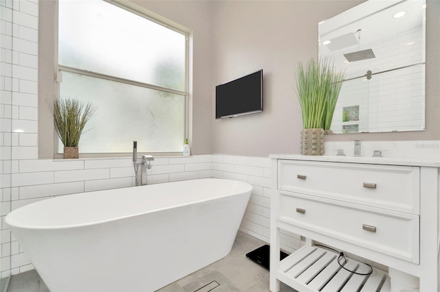 bathroom with tile patterned flooring, vanity, independent shower and bath, and tile walls