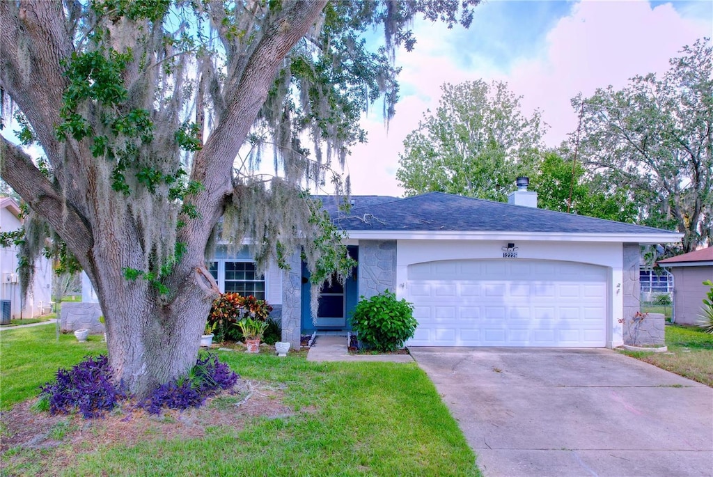 ranch-style home with a garage and a front lawn