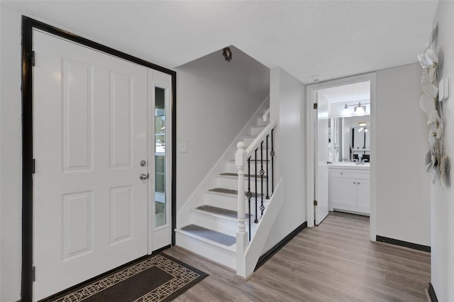 entryway with a textured ceiling and light wood-type flooring