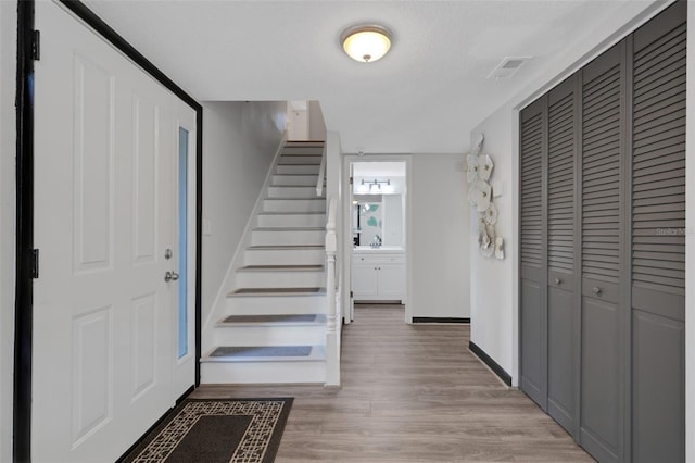 foyer entrance featuring hardwood / wood-style floors and a textured ceiling