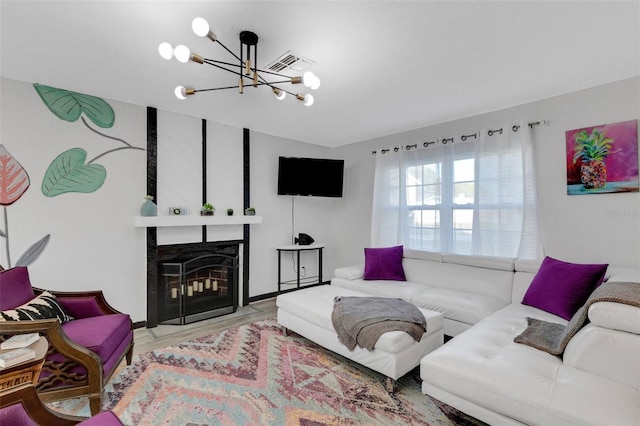 living room with a fireplace, hardwood / wood-style floors, and an inviting chandelier