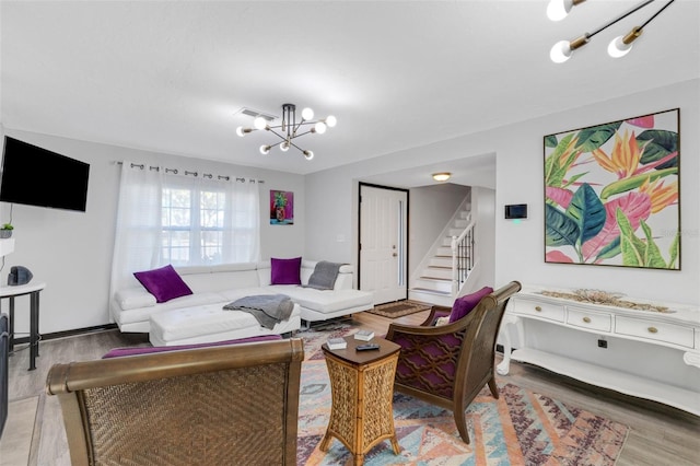 living room featuring wood-type flooring and a notable chandelier