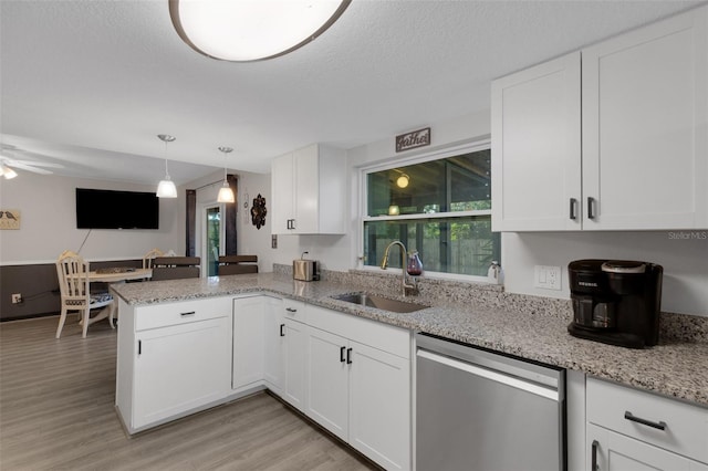 kitchen with white cabinets, sink, stainless steel dishwasher, light hardwood / wood-style floors, and kitchen peninsula