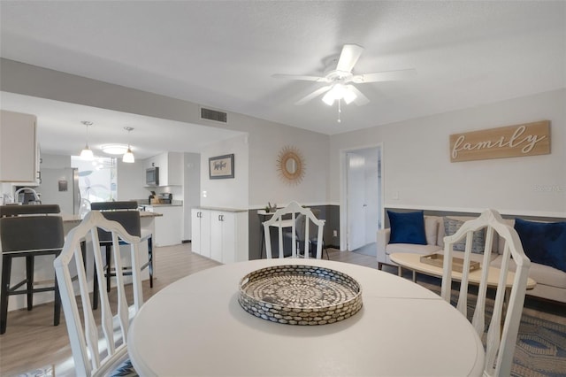 dining room with ceiling fan and light hardwood / wood-style flooring