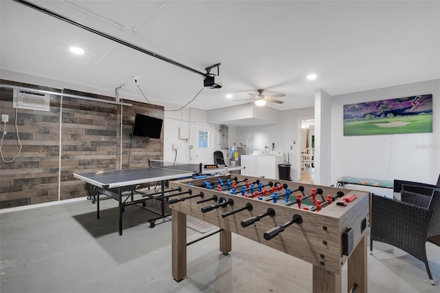 recreation room featuring electric panel, wooden walls, ceiling fan, independent washer and dryer, and a wall unit AC