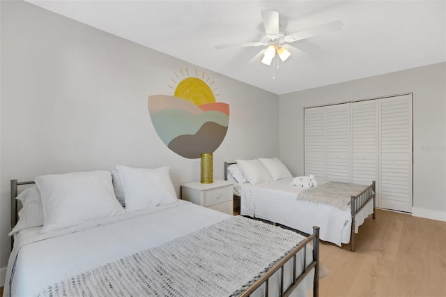 bedroom featuring ceiling fan, a closet, and light hardwood / wood-style flooring