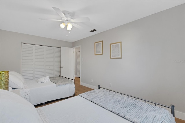 bedroom featuring ceiling fan, wood-type flooring, and a closet