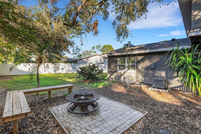 view of yard with a fire pit and central AC unit