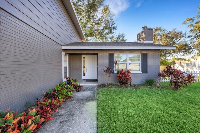 view of exterior entry featuring a yard